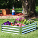 Large, rectangular, sliver garden bed full of lush plants sitting in a yard.