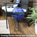 Blue swirl gazing globe in a scroll stand next to a black wicker patio chair.