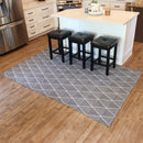 5x7 gray lattice style indoor rug laid out over hardwood floor next to kitchen island with square black bar stools