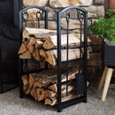 Wood rack with fireplace tools holding logs on two different shelves in a living room near fireplace.