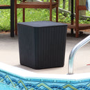 Black faux rattan storage bin/side table with faux wood lid sitting pool side.