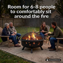 Black Cosmic Fire Pit shown with a burning fire in a backyard gathering area, surrounded by four seated adults, highlighting its spacious design with room for 6–8 people to comfortably sit around the fire.