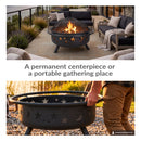 Black Cosmic Fire Pit shown as a centerpiece on a modern outdoor patio with a burning fire, alongside a second image demonstrating its portability with a person lifting the fire bowl by its circular handles.