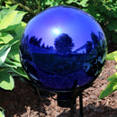 Blue mirrored surface gazing ball displayed in the backyard.
