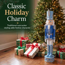 Blue Kristoff Christmas Nutcracker shown beside a decorated Christmas tree and wrapped gifts, featuring traditional nutcracker styling that adds classic holiday charm to a festive indoor space.