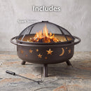 Cosmic Fire Pit in bronze shown with burning logs and illuminated star and moon cutouts, highlighting the included domed mesh spark screen and fire poker.