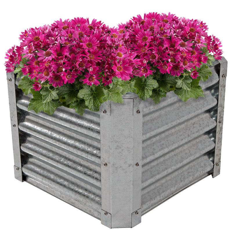 Metal steel garden bed with pink flowers planted inside.