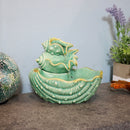 The stacked seashells tabletop water fountain is displayed on a counter in a home.
