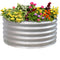 Silver, round, raised metal garden bed with colorful flowers.