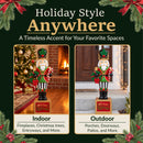 Traditional Christmas nutcracker decoration dressed in a festive red, green, and gold uniform, holding a holiday wreath and candy cane while standing on a Merry Christmas base. Shown in indoor and outdoor settings beside a decorated Christmas tree, cozy fireplace, and front porch, highlighting its versatility for seasonal displays.