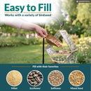 Modern Mosaic Fly-Through Bird Feeder in mirrored diamond shown being filled with birdseed in a garden. Open design makes filling easy and works with millet, sunflower, safflower, and mixed seed.