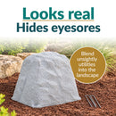 Infographic featuring a tall, tapered light gray faux rock cover with a realistic stone texture in a mulched garden bed. Text reads “Looks real, Hides eyesores” with a callout explaining how it blends unsightly utilities into the landscape. Two metal ground stakes are displayed beside the rock.