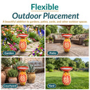 Flexible outdoor placement infographic showing a red Mediterranean-style glass bird bath in four settings: a colorful garden, patio, courtyard, and grassy yard. Text highlights its use in gardens, patios, yards, and other outdoor spaces.