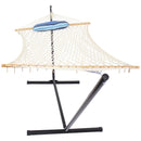 Rope hammock with blue, stripped pillow tied to the spreader bar hooked on a black hammock stand. 