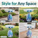 Mosaic Bloom Glass Bird Bath in indigo shown in four outdoor settings, including a patio, garden, backyard, and deck, highlighting its decorative blue, indigo, and aqua floral mosaic design for a variety of spaces.
