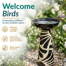 Black-and-cream decorative glass birdbath displayed in a garden with a bird perched on the bowl, highlighting its outdoor versatility, bird-friendly design, and decorative style.