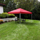 Red 12'x12' pop up canopy with white frame set up on a backyard lawn.