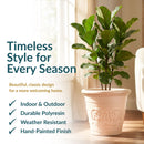 Cream-colored decorative planter with a lush fiddle-leaf fig, featuring a raised floral design and a classic rounded rim. Text highlights indoor and outdoor use, durable polyresin, weather resistance, and a hand-painted finish.