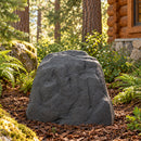 Dark gray faux rock cover with a realistic textured stone finish placed in a mulched garden bed surrounded by ferns, moss-covered rocks, and trees beside a rustic log cabin.











Is this conversation helpful so far?