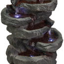 Close-up of a cascading rock fountain featuring textured gray stone basins, flowing water, and glowing blue LED lights illuminating the tiered waterfalls against a white background.