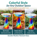 Vibrant multicolored glass birdbath shown as a bird feeder, garden focal point, and birdbath, with red, blue, green, and yellow swirling patterns. Highlights durable, weather-resistant glass.