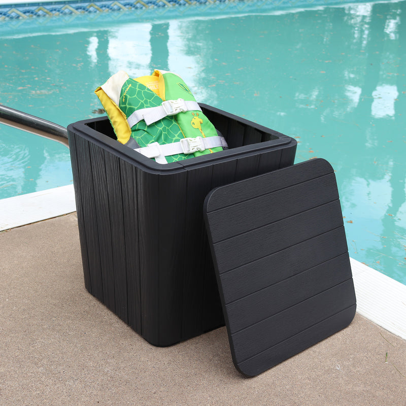 Black faux wood storage bin sitting pool side with a child life vest inside.