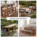 Sunnydaze Teak Trestle Bench in four different situations, the top left is in a dining room farm house interior aesthetic, the top right is by a campfire in a backyard, the bottom left is in a garden with dappled lighting, and the final image is at the foot of the bed in a clean minimalistic scene.