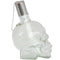 Profile view of a white, clear skull torch with metal snuffer cap and chain.