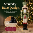 Green and red Christmas nutcracker statue with a sturdy square base, featuring a close-up of the base and text highlighting stable placement on flat surfaces.