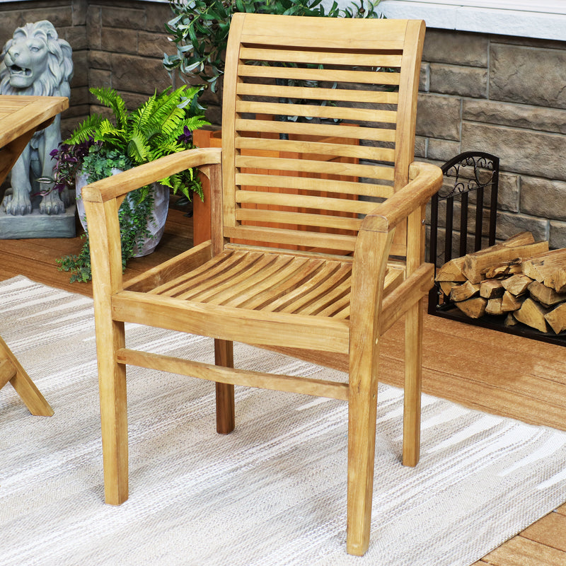 Wooden teak arm chair sitting on a gray outdoor rug.