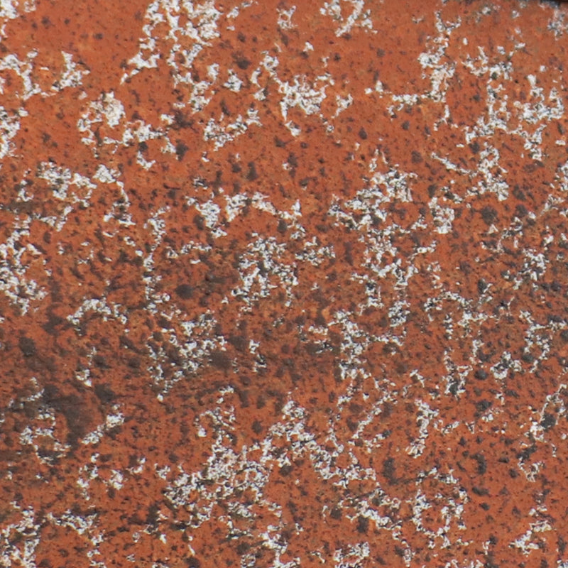 Detail image of orange rusted metal of the outdoor windmill statue.