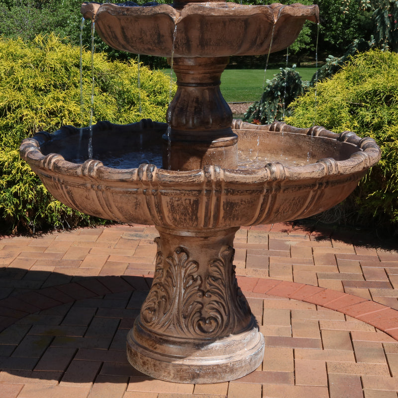 Bottom tier and pedestal of a large tiered fountain on a brick stone patio.