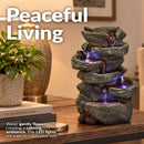Rock-style tabletop fountain with cascading water and purple LED lighting, designed to create a calming indoor ambiance.