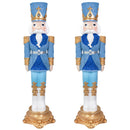 Two blue and gold nutcracker soldiers standing upright on ornate gold decorative bases, wearing blue uniforms, white beards, and gold-trimmed crowns against a white background.