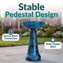 Crackled Glass Mosaic Bird Bath in deep ocean swirl shown outdoors on a patio, featuring a secure bowl connection and a wide, stable pedestal base.