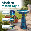 Crackled Glass Mosaic Bird Bath in deep ocean swirl shown outdoors on a patio, featuring handcrafted mosaic glass with a shimmering finish and vibrant blue and turquoise colors that catch the light.