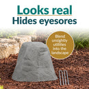 Infographic featuring a tall, tapered gray faux rock cover with a realistic stone texture in a mulched garden bed. Text reads “Looks real, Hides eyesores” with a callout explaining how it blends unsightly utilities into the landscape. Two metal ground stakes are displayed beside the rock.