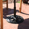 Black cast iron outdoor patio umbrella base stand on outdoor patio.
