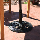 Black cast iron outdoor patio umbrella base stand on outdoor patio.
