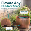 Copper Embossed Panel Hose Pot shown storing a coiled garden hose, featuring an open-top design for easy access and raised feet that support drainage and stability.
