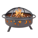 Rear view of the black Cosmic Fire Pit with burning logs and flames beneath the domed mesh spark screen, highlighting the illuminated star and moon cutouts, circular side handles, and angled metal legs.