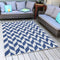 An outdoor deck rug covers the floor near two outdoor couches.