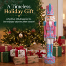 Pink Kristoff Christmas Nutcracker shown beside a decorated Christmas tree and wrapped gifts, highlighting a festive holiday gift designed to be enjoyed season after season.