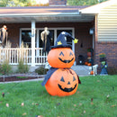 Two smiling jack-o'-lanterns stacked and wearing a witch's hat and cape are displayed in the front yard.


