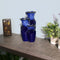 The blue glazed pitchers ceramic tabletop fountain is displayed on an entryway table.
