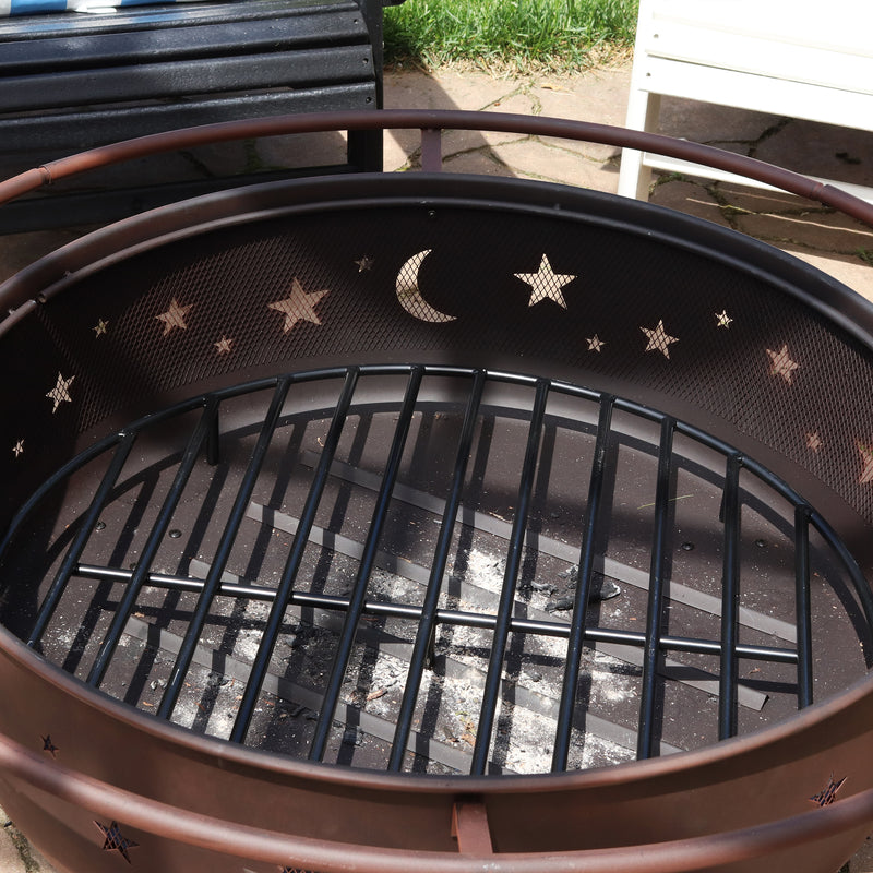 Black, metal wood grate inside of a fire pit with star and moon mesh cut outs.