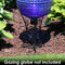 A black steel gazing ball globe stand holds a shining gazing globe in a garden,
