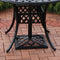 Black umbrella base under a black table on brick patio.