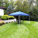Navy blue canopy set up on a lawn with a woman reading underneath.