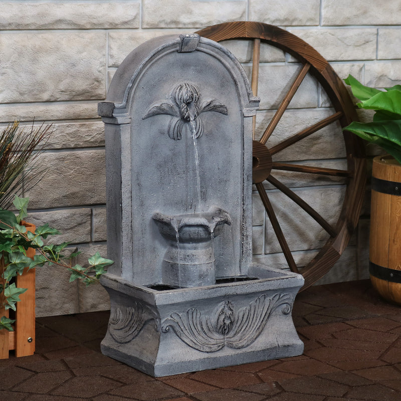 French-inspired outdoor wall-mounted fountain with running water displayed on the patio.

